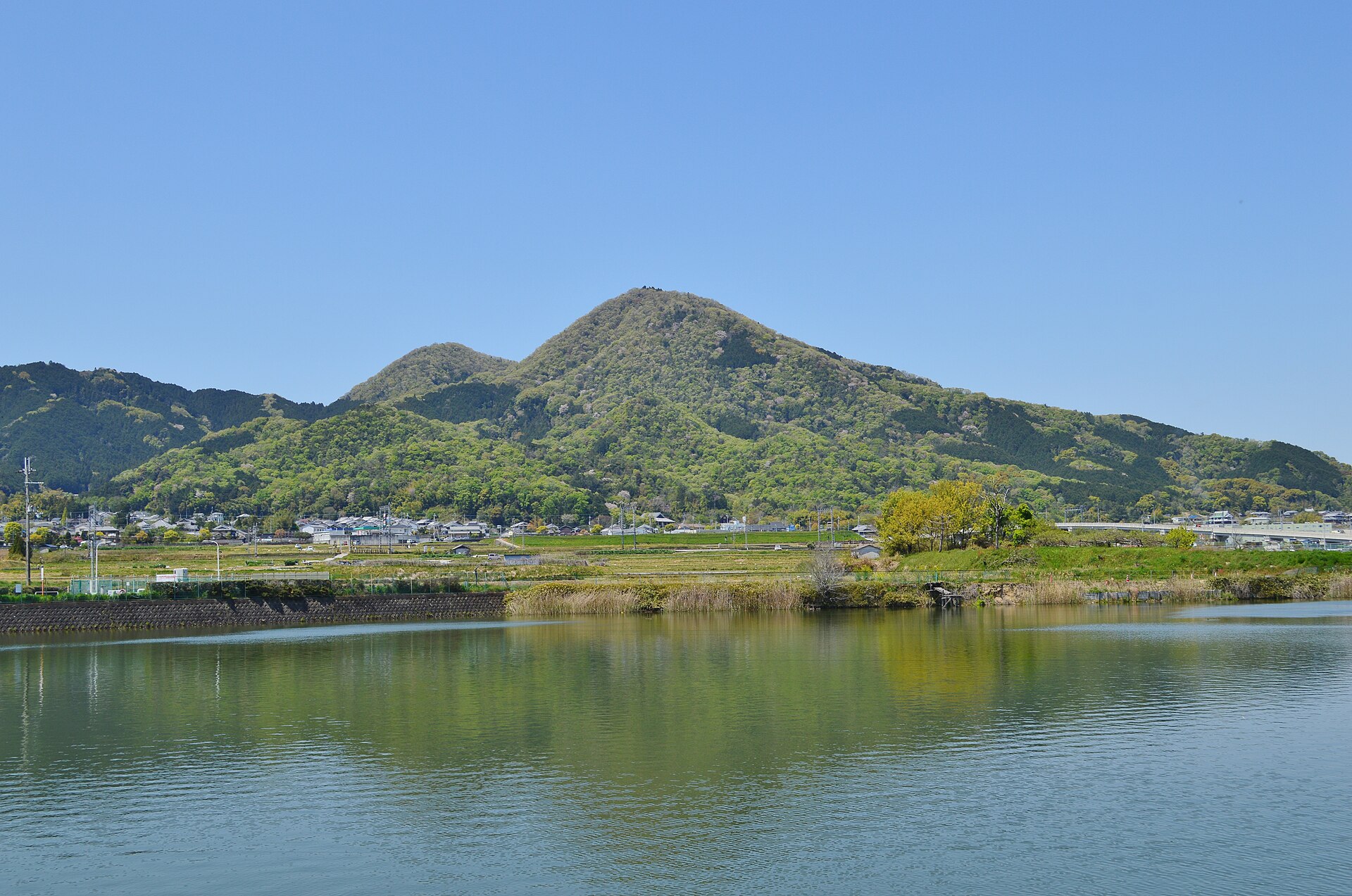 池の向こうにそびえる二上山の全景